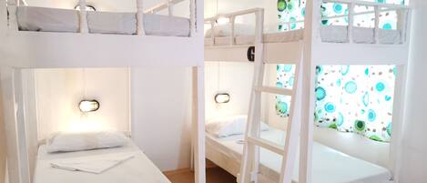 A bunk bed room with two beds, each with a headboard and a small ladder.