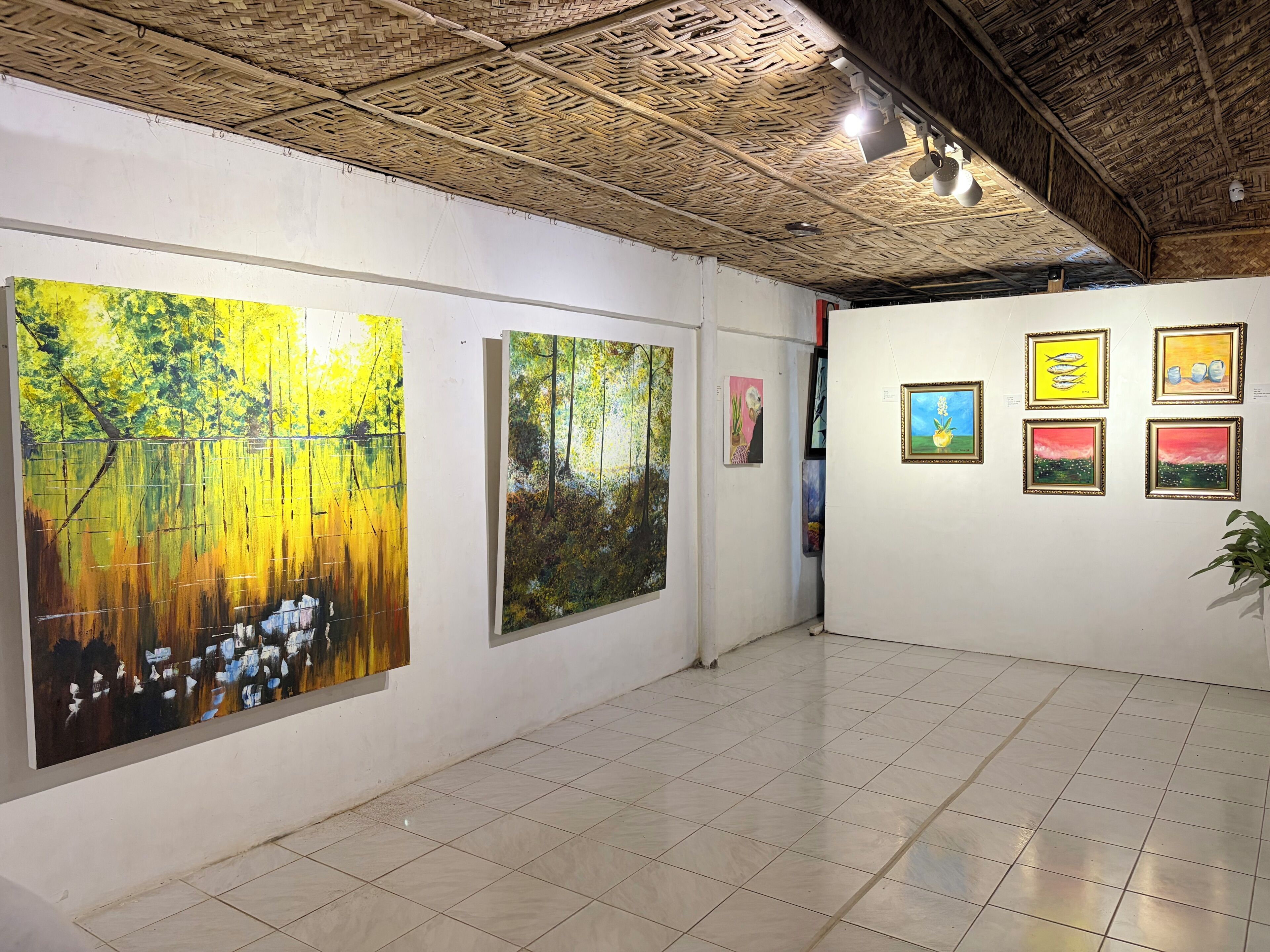 Una galería de arte con pinturas en las paredes y un piso de baldosas.