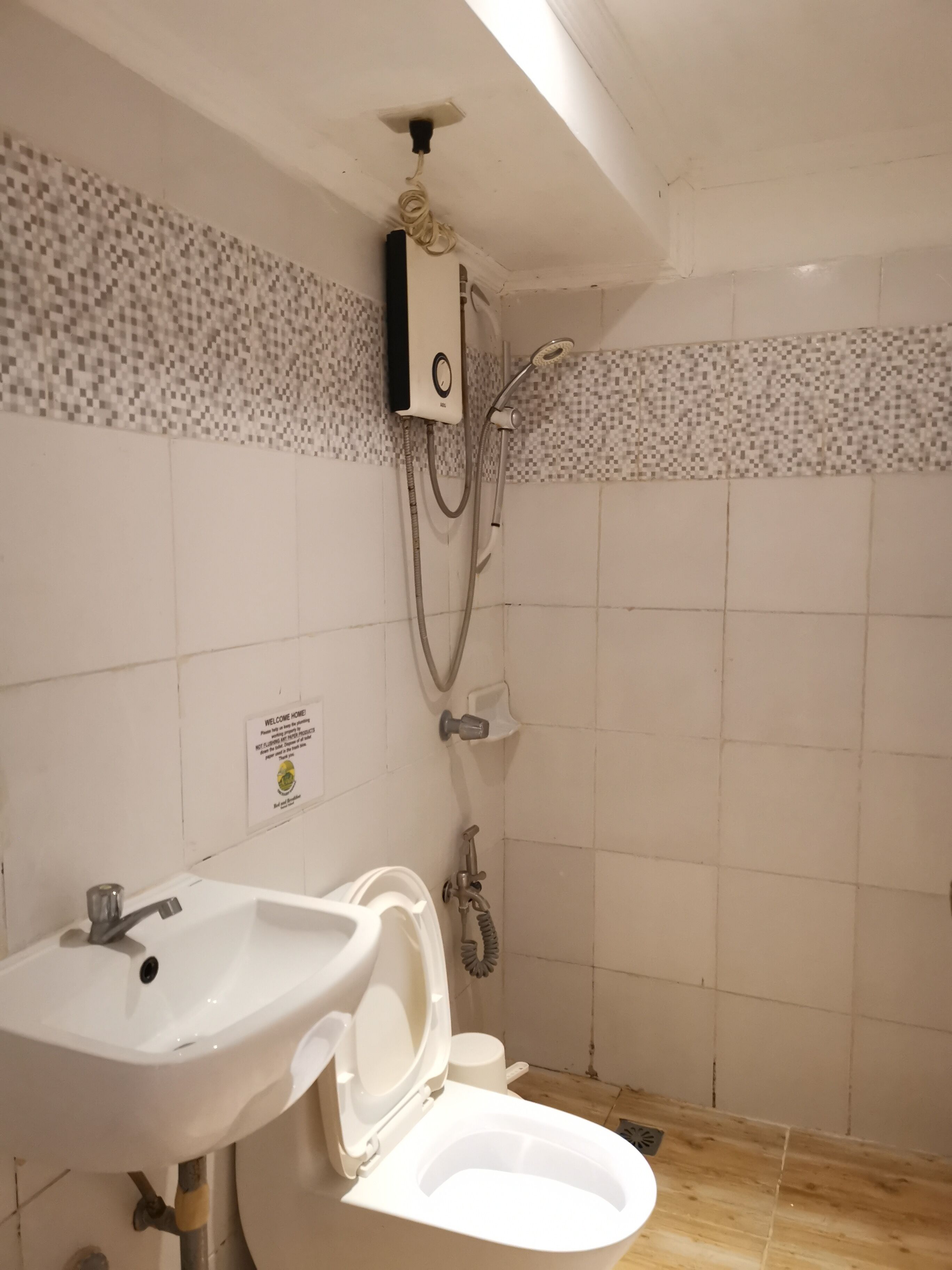 A bathroom with a white sink, toilet, and shower.