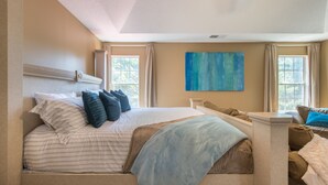 A bedroom with a large bed, a headboard, a window, and a blue abstract painting on the wall. - Comfort and Style on the Colonnade (Rex)
