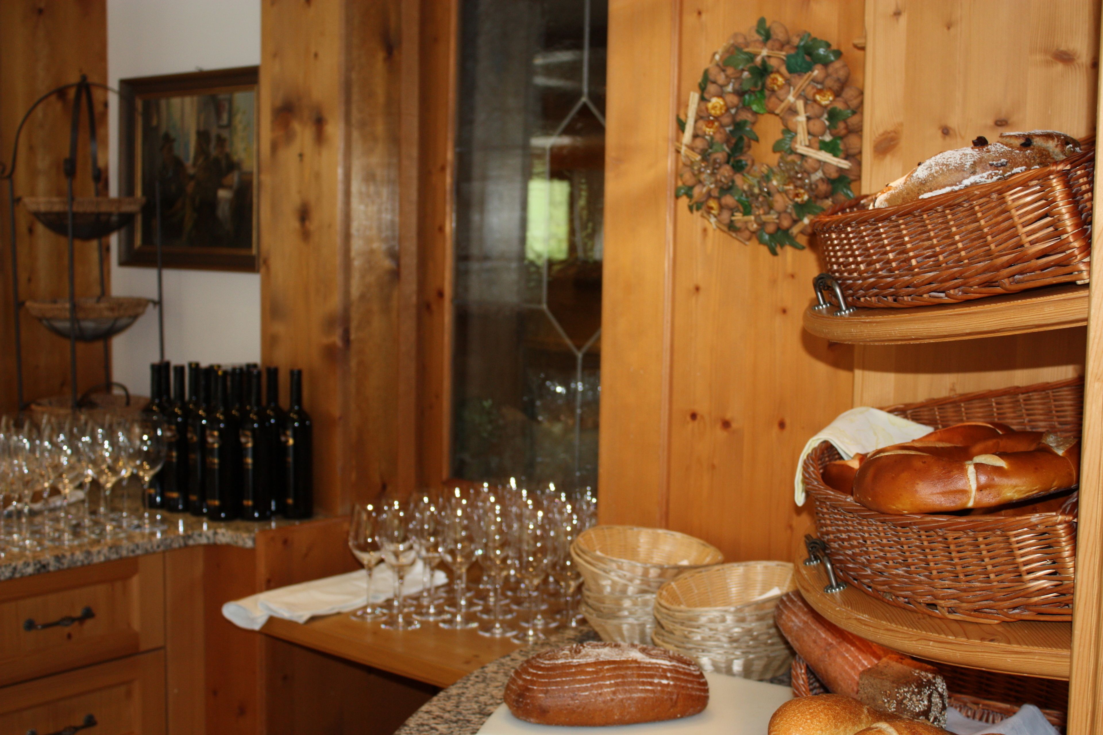 A wooden interior with a table displaying bread, wine glasses, and bottles.