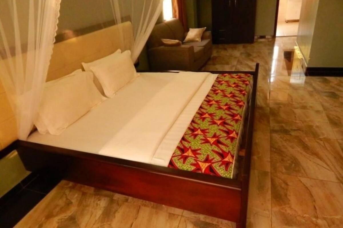 Un lit à baldaquin, un canapé et une couvre-lit à motifs.
