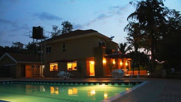 Una piscina con una casa al fondo.