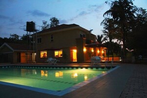Una piscina con una casa al fondo.