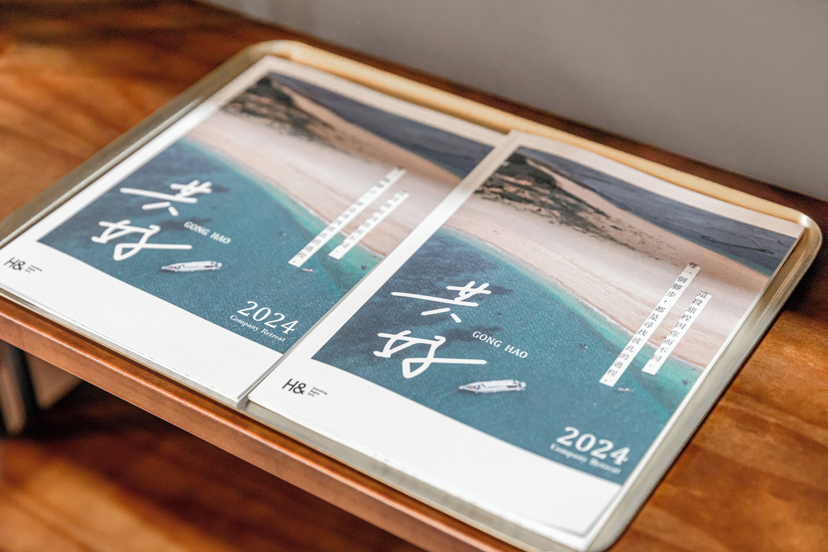 A brochure with the text "GONG HAO 2024" and a scenic beach image.
