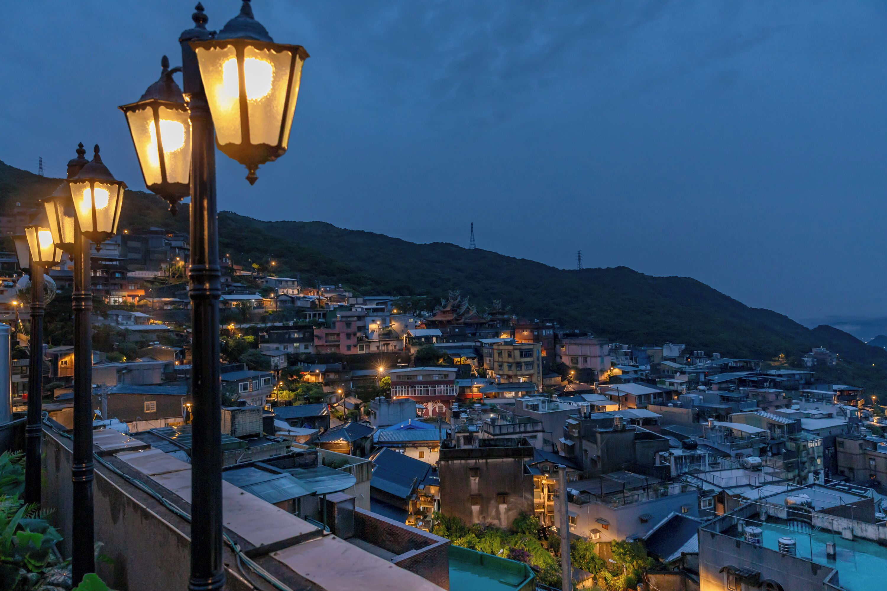 A densely packed urban area with traditional buildings and street lamps.