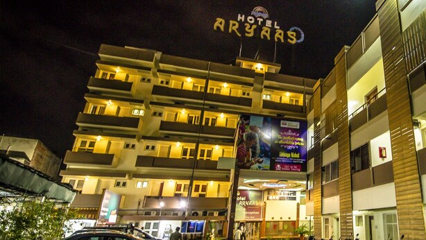 A multi-story hotel with balconies, a reception area, and a parking sign. - Hotel Aryaas (Tirunelveli)