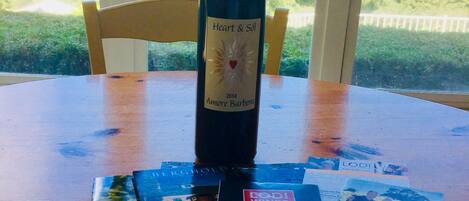 Una botella de vino sobre una mesa con folletos y un mapa.