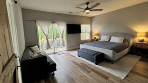 A bedroom with a bed, a desk, a chair, a ceiling fan, and a sliding glass door to the outside. - Sip, Swim, Sleep Soak,Escape! Lodi wineries minutes away (Lockeford)