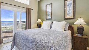 A bedroom with a bed, two bedside tables, a window with curtains, and a view of the ocean. - YOU WILL INDEED be on Cloud Nine when you stay in this beautiful, beachfront home. (St. George Island)