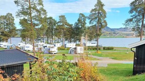 A view of a campground with RVs, trees, and a lake. - Sveastranda Camping (Gjovik)