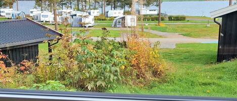 Une vue d'un terrain de camping avec des camping-cars, des arbres et un lac.