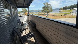 A balcony with a view of a lake, wooden deck, and outdoor seating. - Sveastranda Camping (Gjovik)