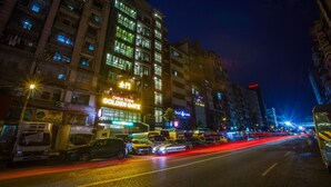 A nighttime city street with illuminated buildings and vehicles. - Golden Gate China Town Hotel (Yangon)