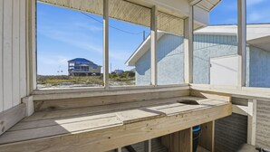 Eine Holzbank mit Blick auf ein Gebäude und einen Strand.