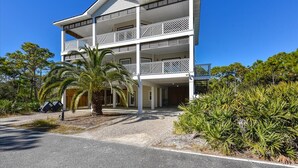 A multi-story building with balconies, a covered entrance, and surrounding vegetation. - CREATE THE PERFECT VACATION experience for the whole family in Pretty Woman! (St. George Island)