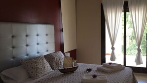 Ein Schlafzimmer mit einer gesteppten Kopfteile, einem blumigen Bettbezug und einem kleinen Bootsmodell auf dem Bett.