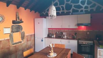 Een koelkast, een kookplaat, kookgerei, borden en bestek