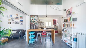 Un espace de vie moderne comprenant une cuisine, un coin repas et une bibliothèque.