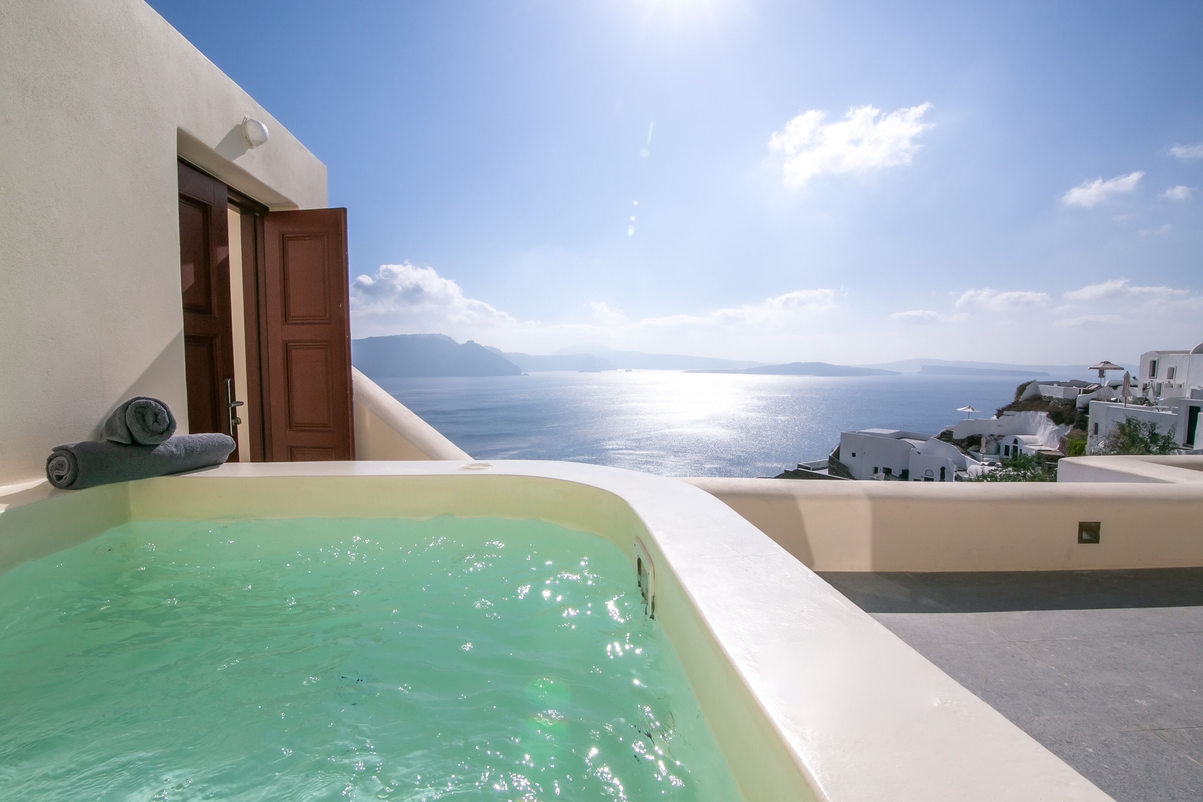 A balcony with a hot tub overlooking a sea view.
