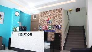A hotel reception area with a reception desk labeled "RECEPTION," a staircase, and a wall with the hotel's logo and name. - SS Hotel Seremban (Seremban)