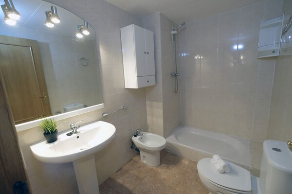 A bathroom with a sink, bidet, toilet, and bathtub. - LOS RISCOS 2 (La Pineda)