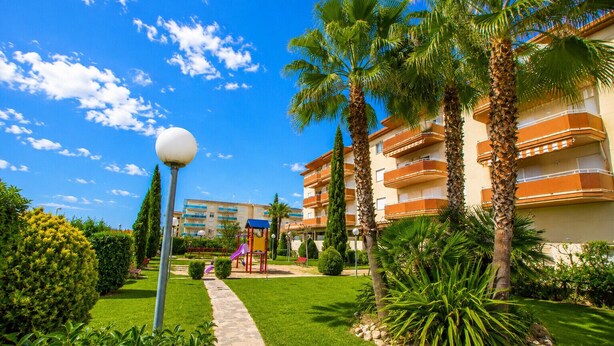 A residential building with balconies, a pathway, and a playground. - LOS RISCOS 2 (La Pineda)