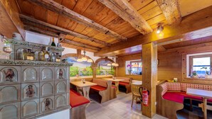 Un intérieur rustique avec des poutres en bois, une fresque murale et des coins salon.