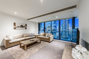 Relax in this stylish living room with a city view, featuring two sofas, a coffee table, and a rug.