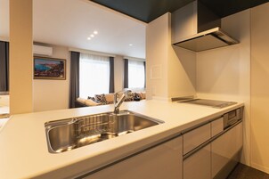 Una cocina moderna con un lavaplatos de acero inoxidable, horno empotrado y microondas.