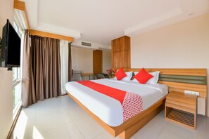 A modern hotel room with a large bed, wooden headboard, and a small bedside table. - OYO 143 Dday Resotel Pattaya Hotel (Pattaya)