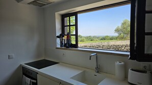 A kitchen with a window, a sink, a stove, and a toaster. - Arrábida Sea & Country side Villa (Azeitão)