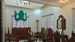 Una sala de estar tradicional con un conjunto de sofá, sillones, una mesa de centro y un espejo grande.
