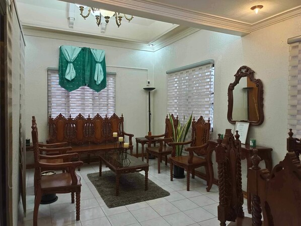 A traditional living room with a sofa set, chairs, a coffee table, and a large mirror.