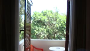 A balcony with a red chair and a small white table. - Anya Studios (Corfu)