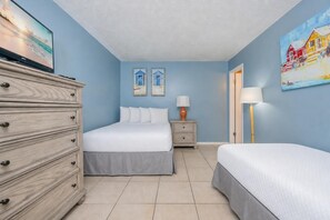 Un dormitorio con cama, cómoda, mesitas de noche y decoración en la pared.