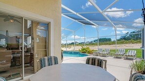 A covered patio with a pool, outdoor seating, and a view of the beach. - EV_234 - 4 Bed 2 Bath House with Games Room and Access to Resort Amenities (Davenport)
