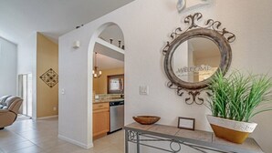 A modern kitchen with a dining area, a decorative mirror, and a welcome sign. - EV_234 - 4 Bed 2 Bath House with Games Room and Access to Resort Amenities (Davenport)