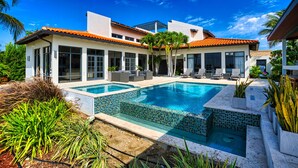 A modern house with a swimming pool, large windows, and outdoor seating. - STUNNING Villa w/Infinity Pool& Outdoor Kitchen! Across from Marriott! (Noord)