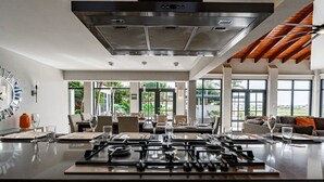 A modern kitchen with a central island, large windows, and a view of the outdoors. - STUNNING Villa w/Infinity Pool& Outdoor Kitchen! Across from Marriott! (Noord)