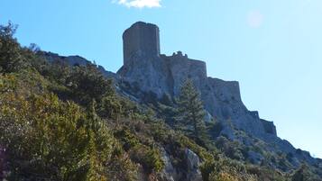 A rugged mountain with a prominent rocky structure, surrounded by dense vegetation.