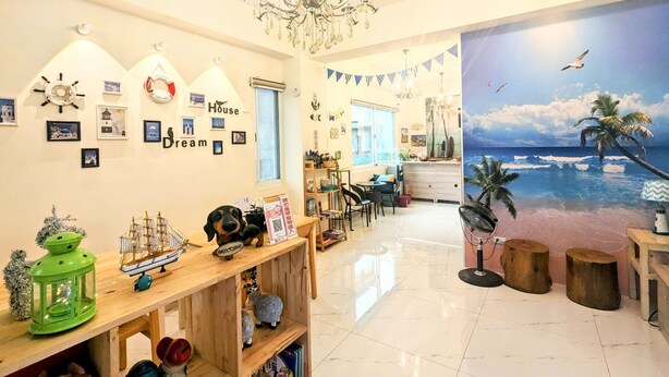 A hotel lobby with a nautical theme, including a ship model, a lighthouse, and a mural of a beach scene.
