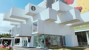 A modern building with a unique modular design, featuring a Starbucks logo and a glass entrance.