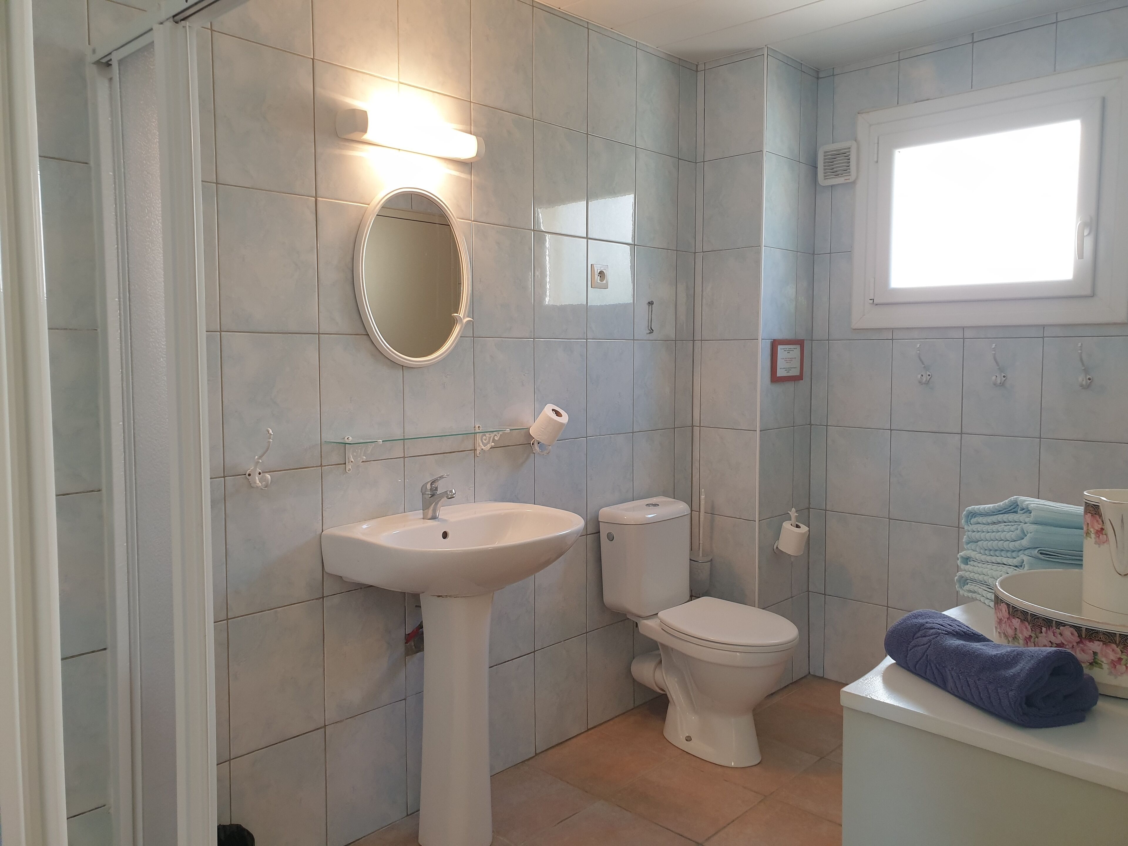 Baño con lavamanos, inodoro y espejo.