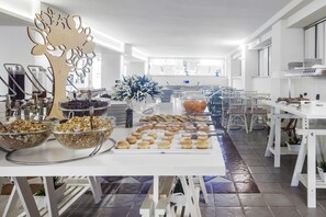A buffet setup with various food items and a decorative tree centerpiece. - Tiffany's (Cattolica)