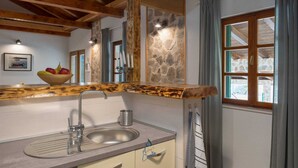A kitchen with a stone backsplash, wooden beams, a sink, and a window with curtains. - Beautiful 3-BR villa with pool and sea view just above Rogoznica (Rogoznica)