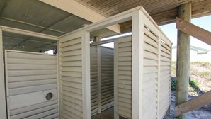A covered outdoor area with a wooden deck and a metal roof structure.