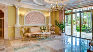 A grand lobby with a marble floor, elegant furniture, and a large window offering a view of the outdoors. - Venera & Anastasia Palace Apartments (Sunny Beach)