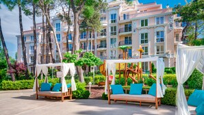 A resort with outdoor seating areas, including a canopy bed and a swing set. - Venera & Anastasia Palace Apartments (Sunny Beach)