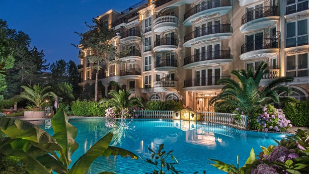 A luxurious hotel with a large swimming pool surrounded by lush greenery and ornate balconies. - Venera & Anastasia Palace Apartments (Sunny Beach)
